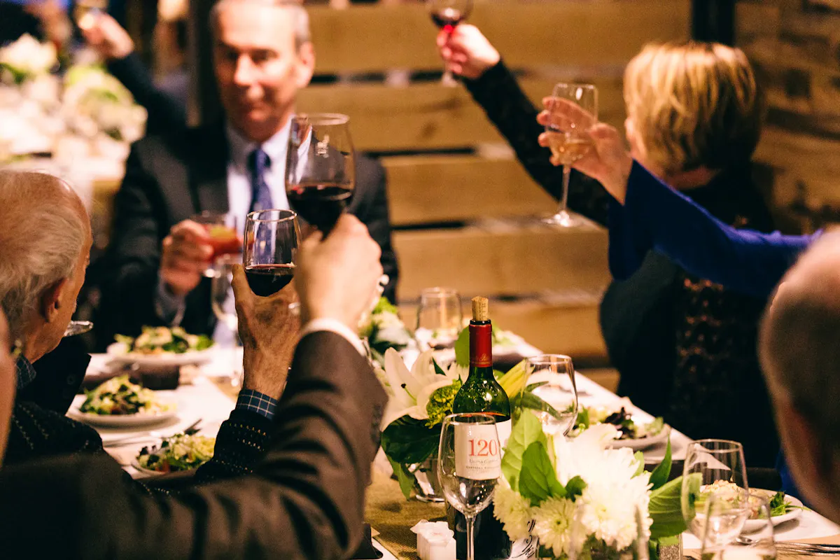a group of people are drinking from a wine glass